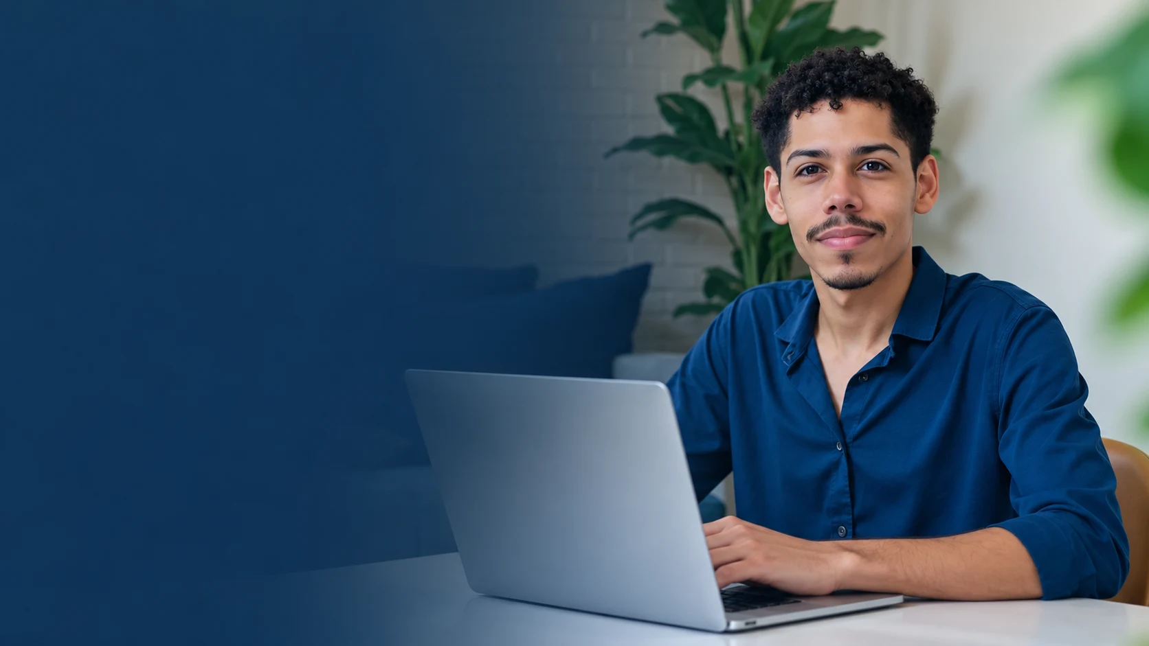João Vitor Barbosa sentado à mesa com um notebook